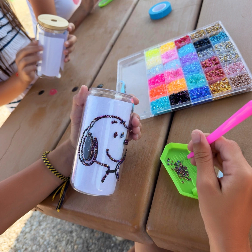 girl decorating bedazzled glass jars with colorful rhinestones at a birthday party workshop in Los Angeles.