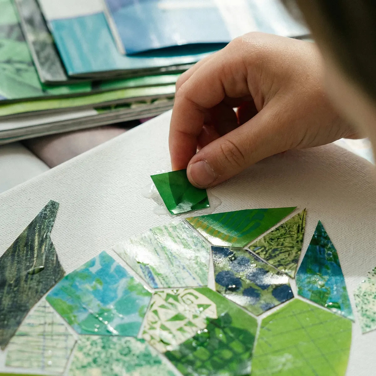 Close-up of a child creating green paper collage artwork during a hands-on kids art workshop in Los Angeles with creative screen-free activities