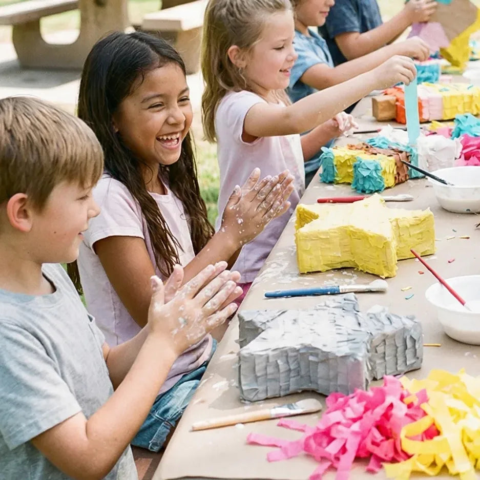 Kids creating a watermelon piñata craft at an outdoor park birthday party in Los Angeles